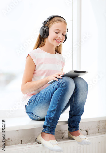 Photo: girl with tablet pc and headphones at home girl with tablet pc and headphones at home