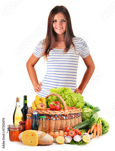 Photo: Young woman with assorted grocery products isolated on white Young woman with assorted grocery products isolated on white