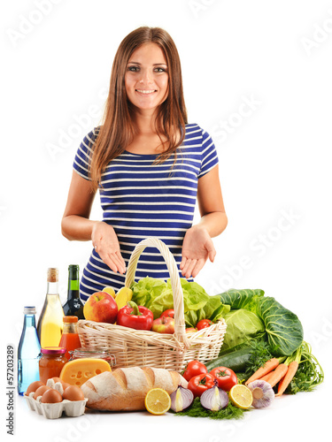 Photo: Young woman with assorted grocery products isolated on white Young woman with assorted grocery products isolated on white