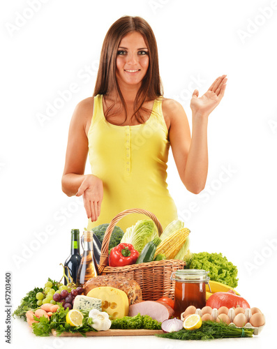 Photo: Young woman with assorted grocery products isolated on white Young woman with assorted grocery products isolated on white