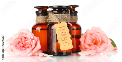 Photo: bottles of oil and roses isolated on white bottles of oil and roses isolated on white