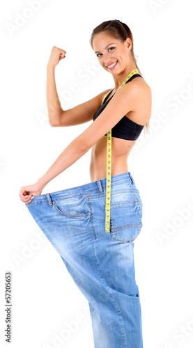 Photo: Slim girl in big jeans isolated on white Slim girl in big jeans isolated on white