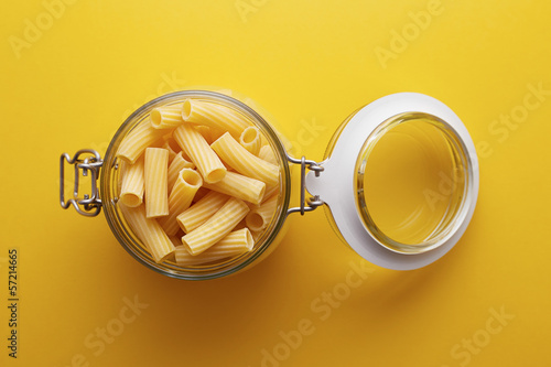 Photo: Raw rigatoni pasta on a glass jar Raw rigatoni pasta on a glass jar