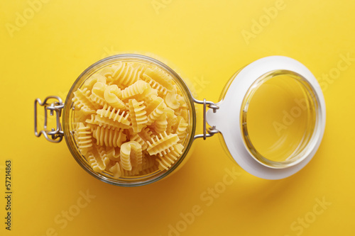 Photo: Raw radiatori pasta on a glass jar Raw radiatori pasta on a glass jar