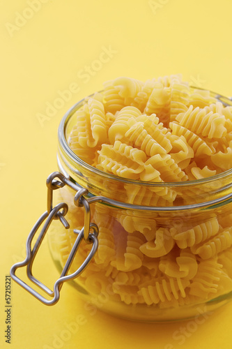 Photo: Raw radiatori pasta on a glass jar Raw radiatori pasta on a glass jar