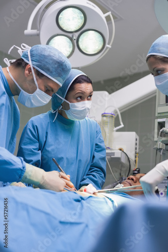 Photo: Serious doctors operating a surgical tools Serious doctors operating a surgical tools