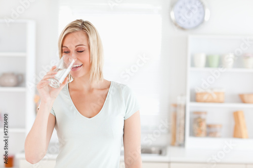 Photo: Charming woman drinking waterwhile standing Charming woman drinking waterwhile standing
