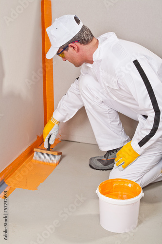 Photo: worker waterproofing around the wall and floor worker waterproofing around the wall and floor