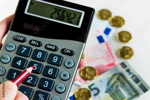 Photo: Hand mit Taschenrechner und Geld Hand mit Taschenrechner und Geld