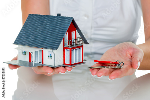 Photo: Immobilienmaklerin mit Haus und Schlüßel Immobilienmaklerin mit Haus und Schlüßel