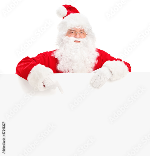 Photo: Santa claus posing behind a blank billboard and pointing Santa claus posing behind a blank billboard and pointing