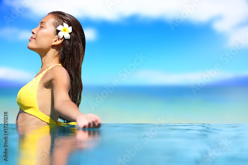 Photo: Relaxing serene woman at travel spa resort pool Relaxing serene woman at travel spa resort pool