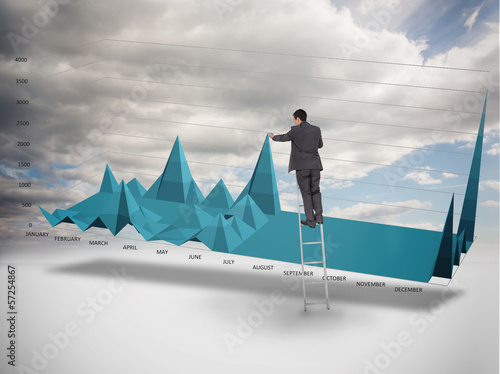 Photo: Businessman on a ladder catching the tip of a chart Businessman on a ladder catching the tip of a chart