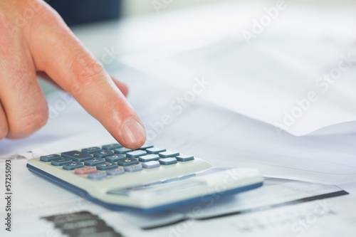Photo: Close up of finger using calculator Close up of finger using calculator