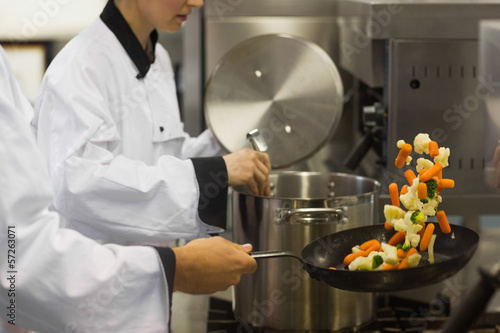 Photo: Two chefs working in a busy kitchen Two chefs working in a busy kitchen