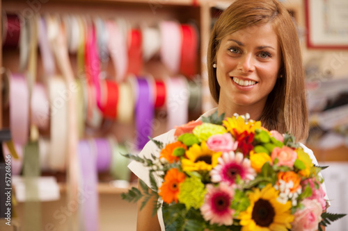 Photo: Beautiful smiling florist with colorful bouquet Beautiful smiling florist with colorful bouquet