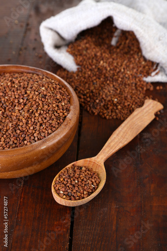 Photo: Buckwheat groats in bowl and wooden spoon closeup Buckwheat groats in bowl and wooden spoon closeup