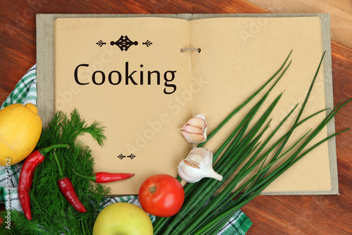 Photo: Cooking concept. Groceries with empty cookbook close up Cooking concept. Groceries with empty cookbook close up