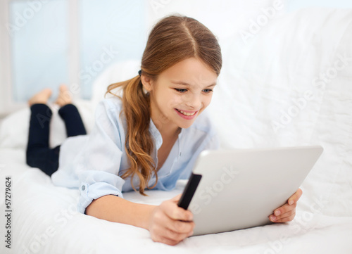 Photo: girl with tablet pc at home girl with tablet pc at home