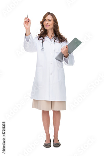 Photo: Brunette doctor holding clipboard and pointing at something Brunette doctor holding clipboard and pointing at something