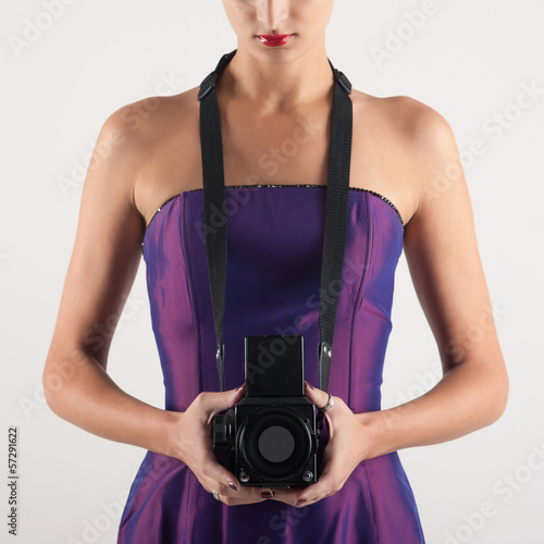 Photo: Elegant woman with medium format camera against white background Elegant woman with medium format camera against white background