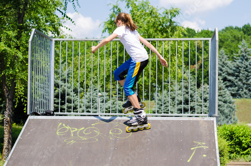 Photo: Young teeange girl on a ramp at a skate park Young teeange girl on a ramp at a skate park