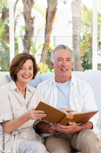 Photo: Seniors looking at their photo album at home Seniors looking at their photo album at home