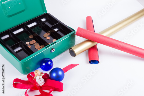 Photo: Schleifen und Geschenkpapier vor fast leerer Geldkassette Schleifen und Geschenkpapier vor fast leerer Geldkassette