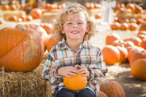Photo: Little Boy Sitting and Holding His Pumpkin at Pumpkin Patch. Little Boy Sitting and Holding His Pumpkin at Pumpkin Patch.
