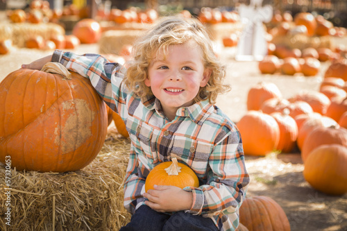 Photo: Little Boy Sitting and Holding His Pumpkin at Pumpkin Patch. Little Boy Sitting and Holding His Pumpkin at Pumpkin Patch.