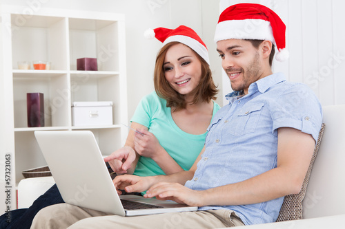 Photo: Young couple looking at laptop Young couple looking at laptop