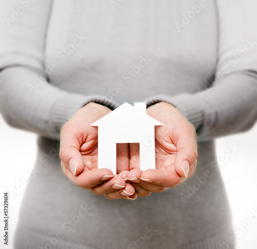 Photo: Hands of woman holding paper house Hands of woman holding paper house