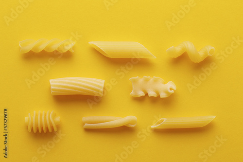 Photo: Different types of pasta on yellow background Different types of pasta on yellow background