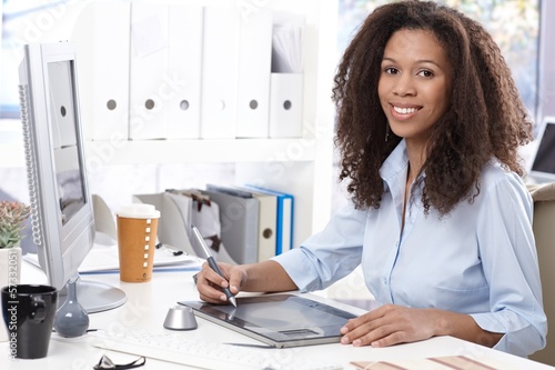 Photo: Smiling office worker with drawing table Smiling office worker with drawing table