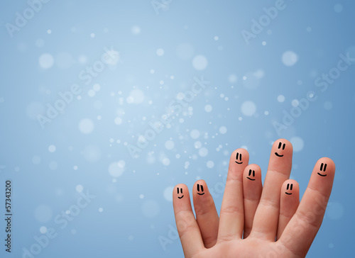 Photo: Happy finger smileys with empty blue bokeh background Happy finger smileys with empty blue bokeh background