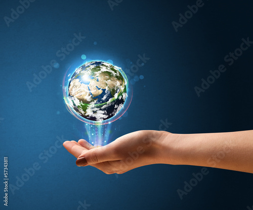 Photo: Woman holding a glowing earth globe Woman holding a glowing earth globe