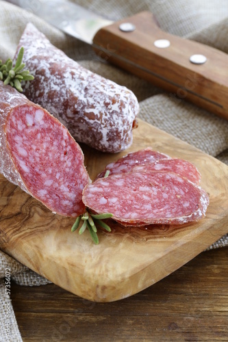 Photo: delicacy smoked sausage (pepperoni) on a cutting board delicacy smoked sausage (pepperoni) on a cutting board