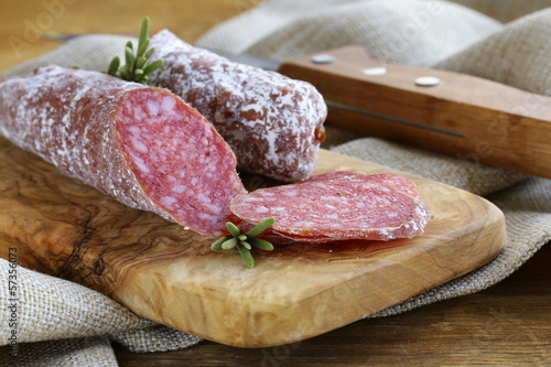 Photo: delicacy smoked sausage (pepperoni) on a cutting board delicacy smoked sausage (pepperoni) on a cutting board