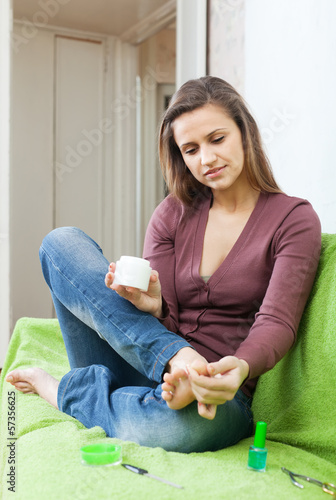 Photo: girl put the cream on toes girl put the cream on toes