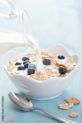 Photo: milk pouring onto cornflakes with blueberry milk pouring onto cornflakes with blueberry