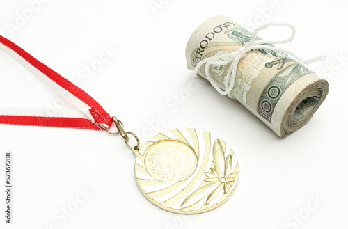 Photo: Gold medal and roll of tied banknotes on white background Gold medal and roll of tied banknotes on white background