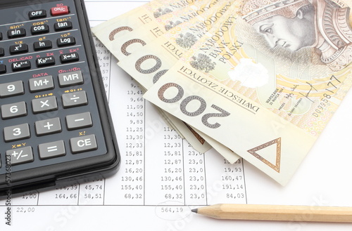 Photo: Money, pencil and calculator lying on spreadsheet Money, pencil and calculator lying on spreadsheet