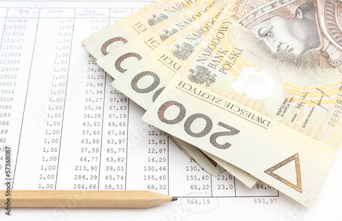 Photo: Money and pencil lying on spreadsheet Money and pencil lying on spreadsheet