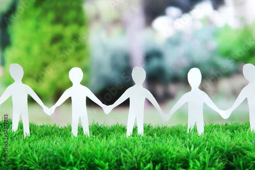 Photo: Paper people in social network concept on green grass outdoors Paper people in social network concept on green grass outdoors