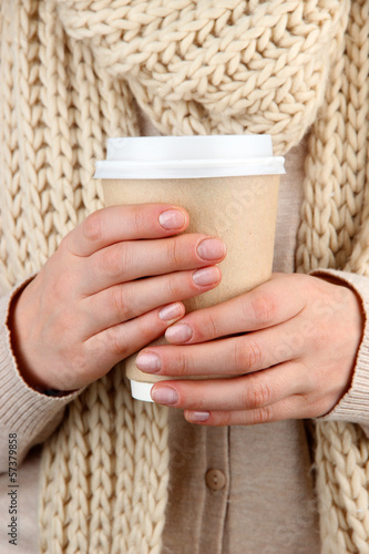 Photo: Hot drink in paper cup in hands close up Hot drink in paper cup in hands close up