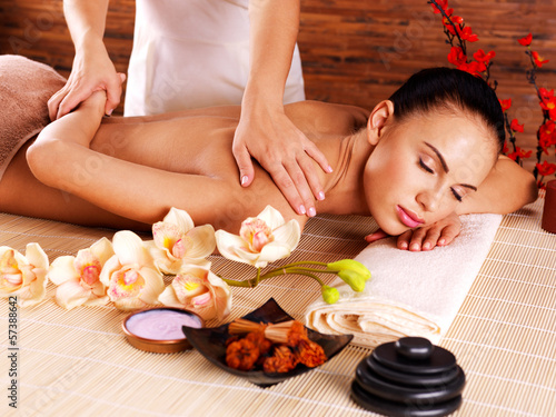 Photo: Masseur doing massage on woman body in spa salon Masseur doing massage on woman body in spa salon