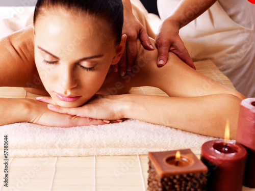 Photo: Masseur doing massage on woman body in spa salon Masseur doing massage on woman body in spa salon