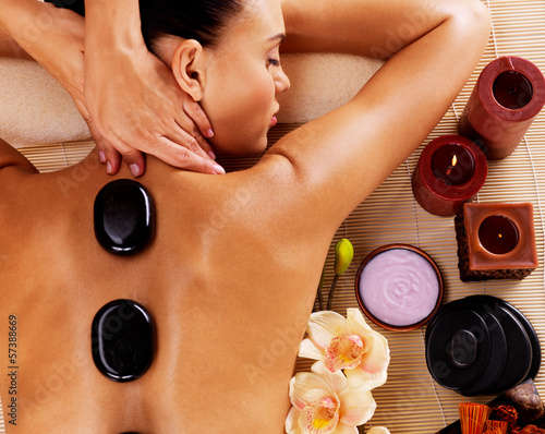 Photo: Adult woman having hot stone massage in spa salon Adult woman having hot stone massage in spa salon