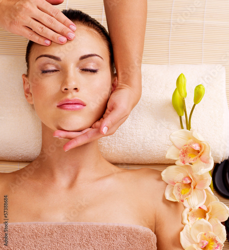 Photo: Masseur doing massage the head of an woman in spa salon Masseur doing massage the head of an woman in spa salon