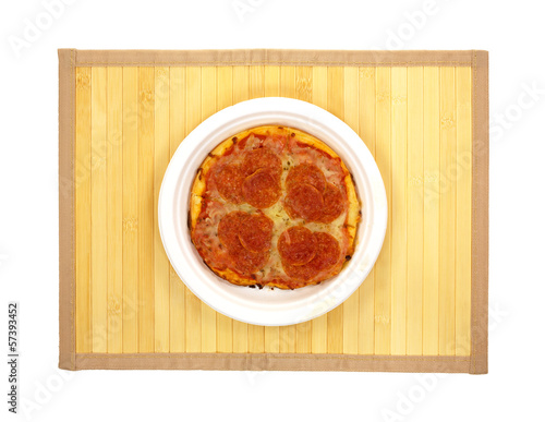 Photo: A plate of pepperoni pizza on a wood place mat A plate of pepperoni pizza on a wood place mat